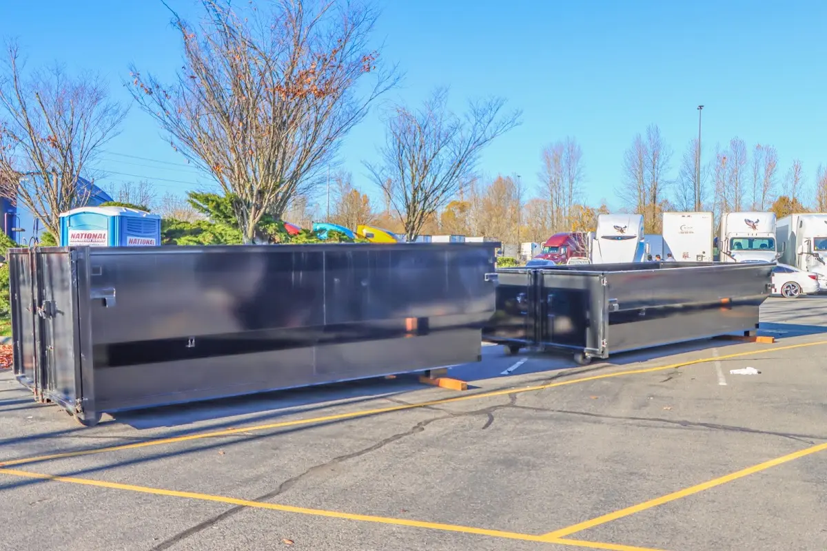 Professional dumpster rental service with roll-off container on residential driveway in Beaver Falls